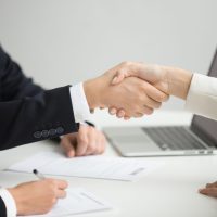 Hr handshaking successful candidate getting hired at new job, cl Employment handshake concept, female hr and successful woman candidate shaking hands getting hired ready to sign job contract concept, employer congratulating welcoming new worker, close up view